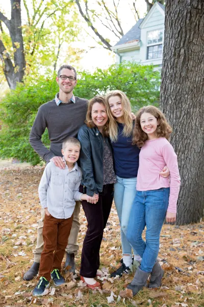 Dr. Foster with his wife Sarah and their three children outdoors in the fall