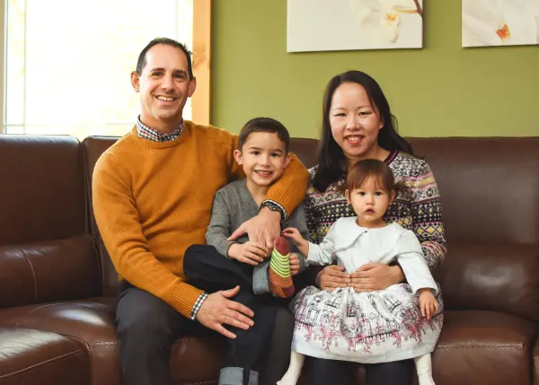 Dr. Lo with her husband and their two children on a couch